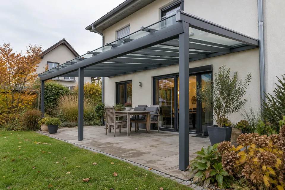 Terrassendach mit dunklem Aluminiumrahmen an einem gewöhnlichen deutschen Wohnhaus